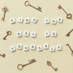 Creative arrangement of vintage keys and motivational text 'Find the key to yourself'.